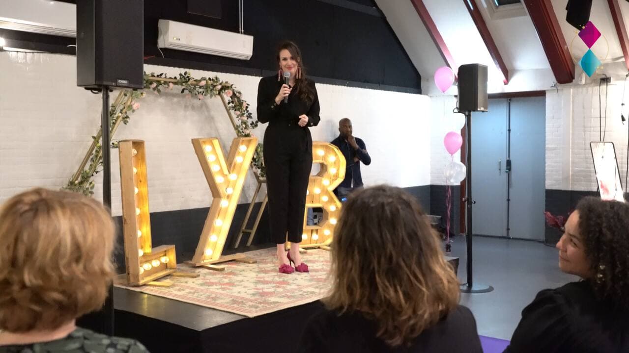 Spreekster op het podium tijdens een boeklancering
