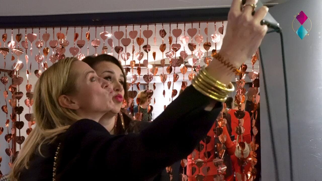 Selfie voor een feestelijk gordijn tijdens een boeklancering