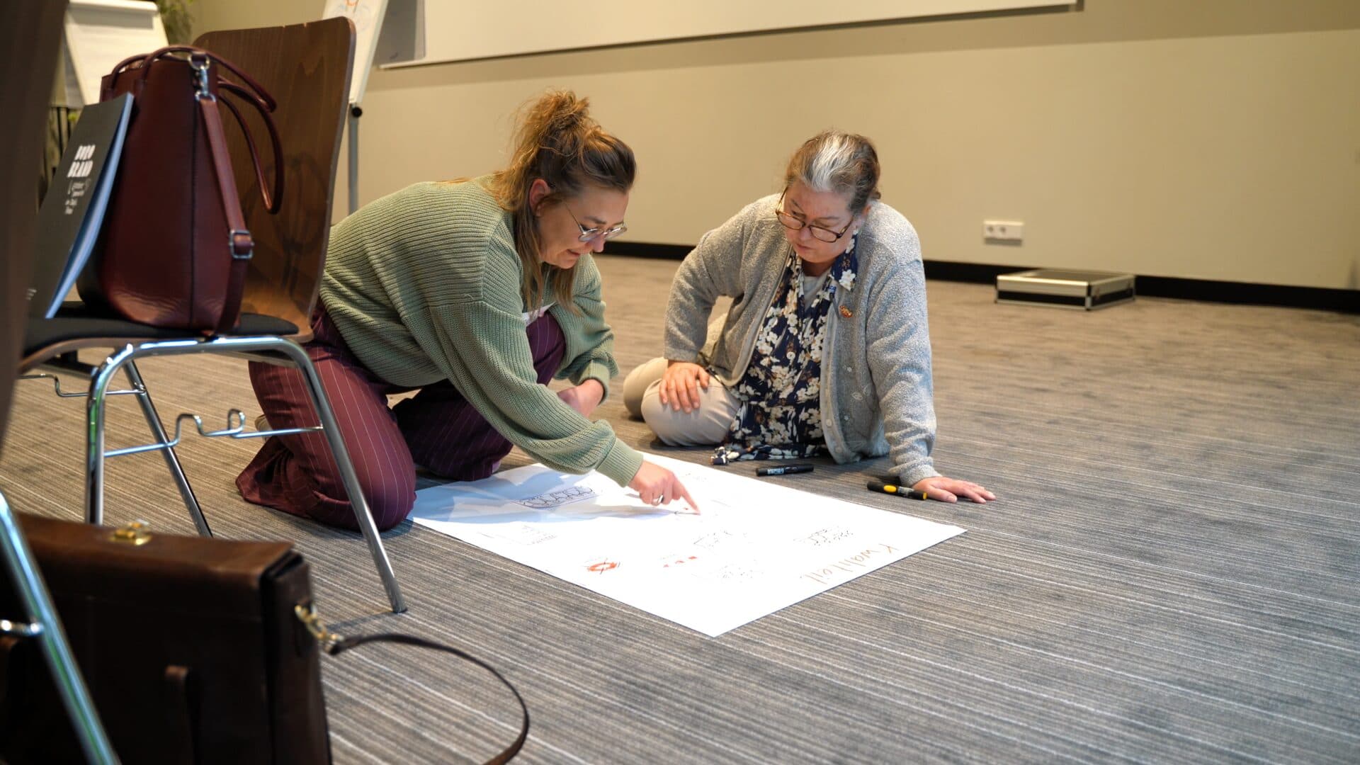 Deelnemers werken samen aan een poster tijdens een workshop