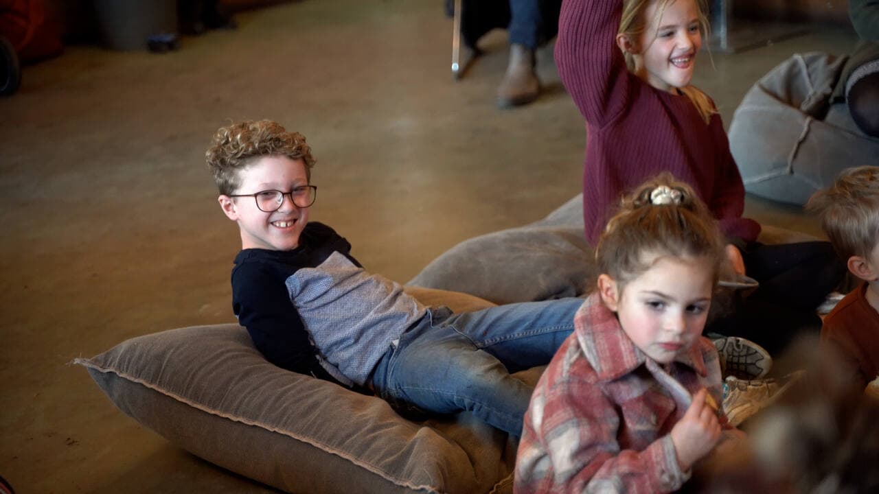Kinderen op een berg zitkussens tijdens een open dag