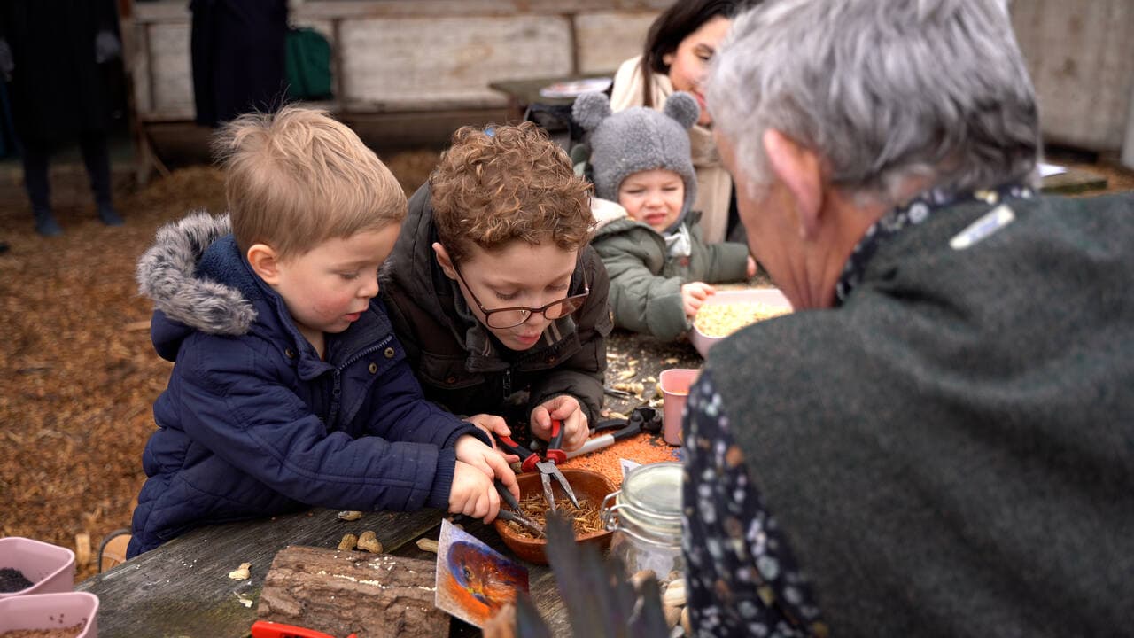 Kinderen ontdekken dierenvoer tijdens een open dag op een boerderij