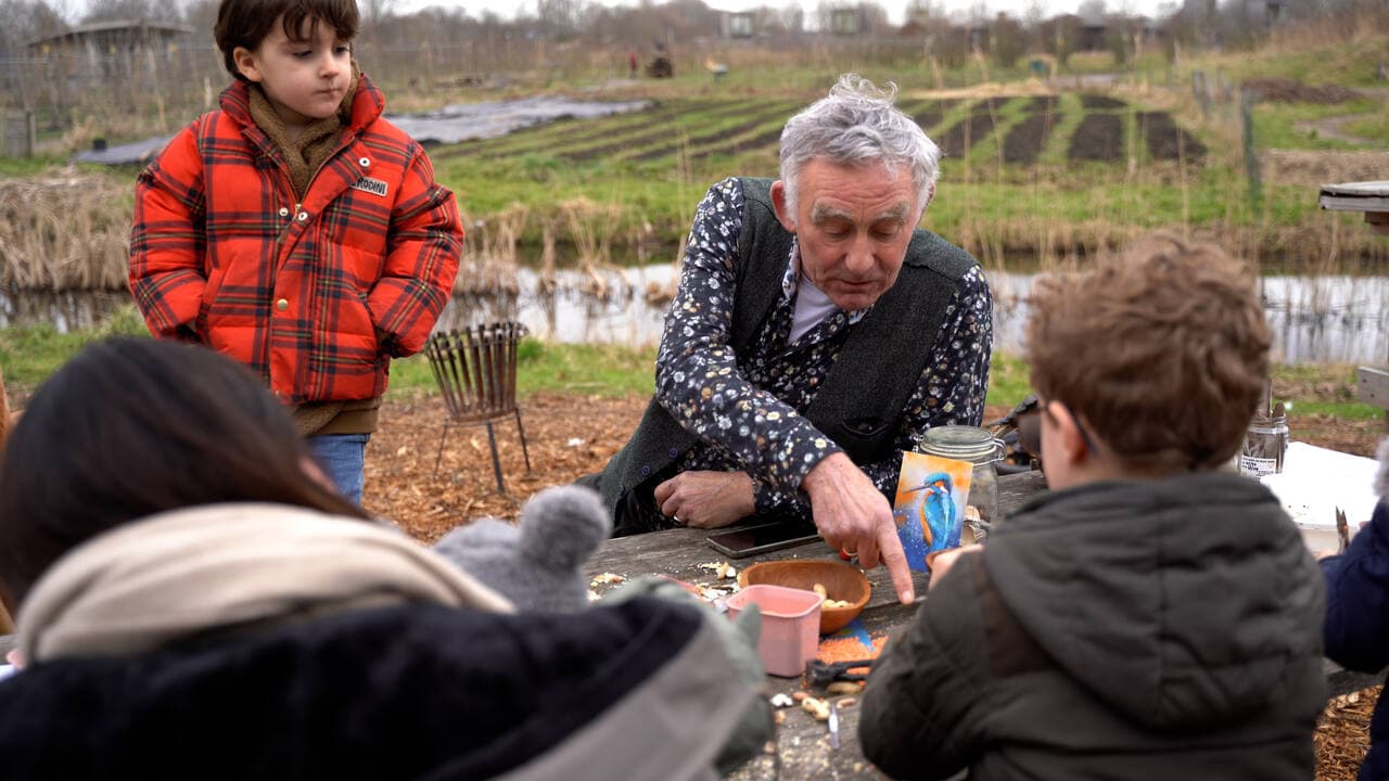 Gids legt iets uit met een vogelkaart tijdens een open dag