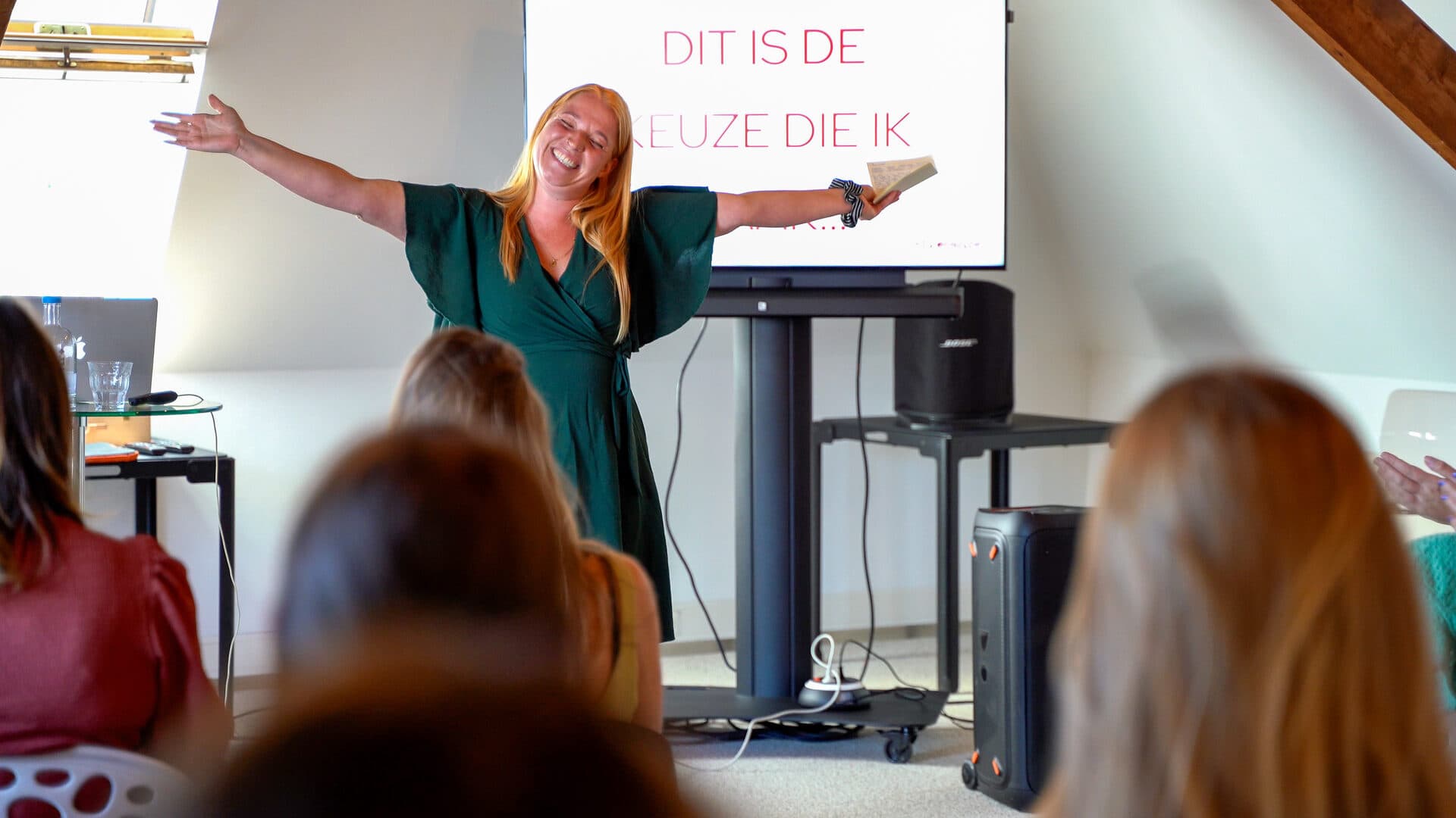 Spreker met open armen tijdens een presentatie